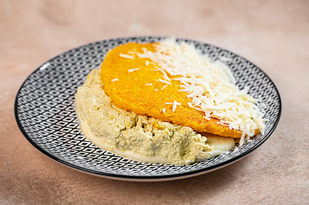Stuffed arepa made from cornmeal, traditional cuisine of Colombia and Venezuela, a Food & Drink Photo by zakiroff