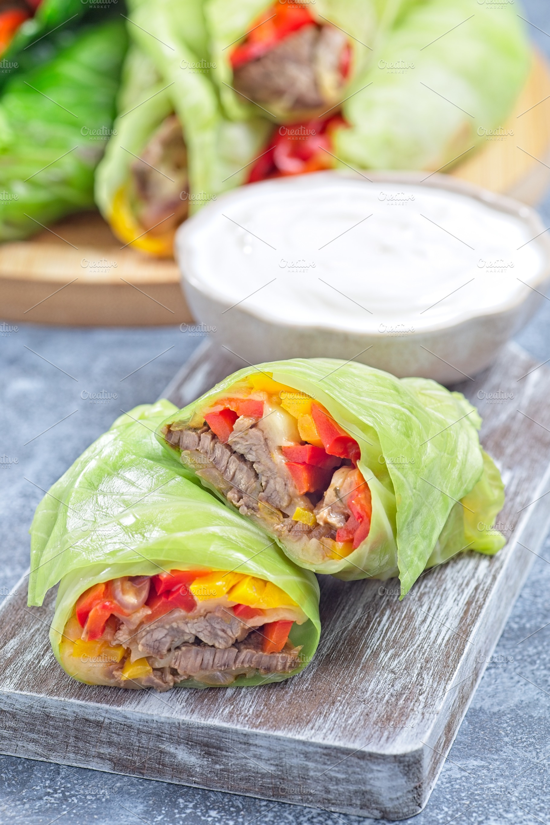 Closeup cut of beef and vegetable cabbage leaves wraps, served with plain yogur, a Food & Drink Photo by iuliia_n