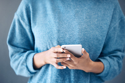 Phone, hands and woman texting in studio for internet, search or social media on grey background. Online, communication and girl searching on smartphone, website or app while reading isolated closeup, a Photo by Peopleimages.com