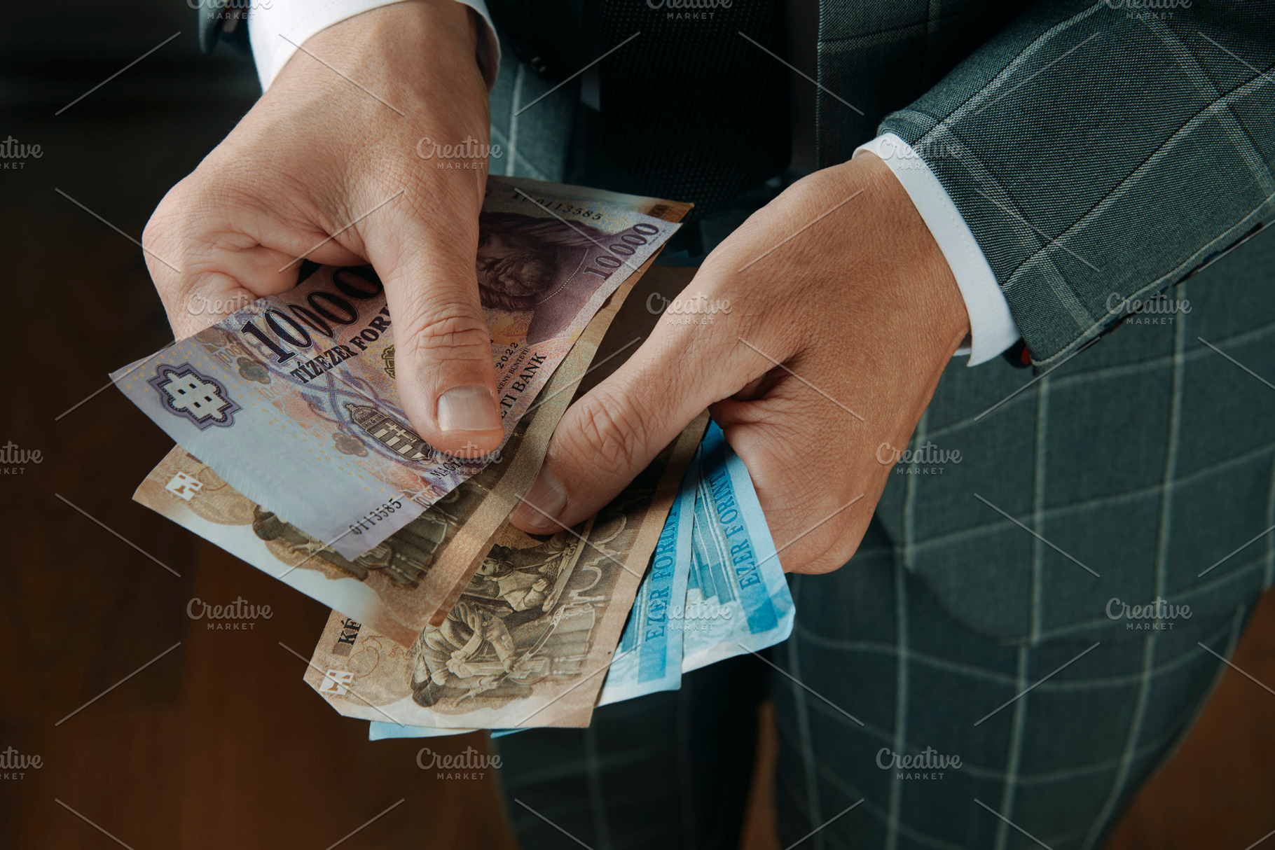 businessman counting hungarian forint banknotes, a Photo by Nito