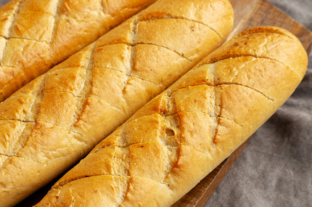 Homemade French Baguette with Garlic Filling on a wooden board,, a Food & Drink Photo by LiudmylaChuhunova