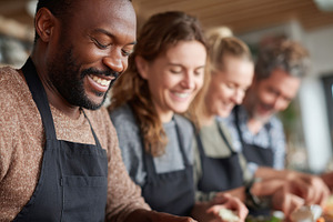Friends enjoy cooking together in a cozy kitchen during a weekend gathering, a Person Photo by AlyaAnd