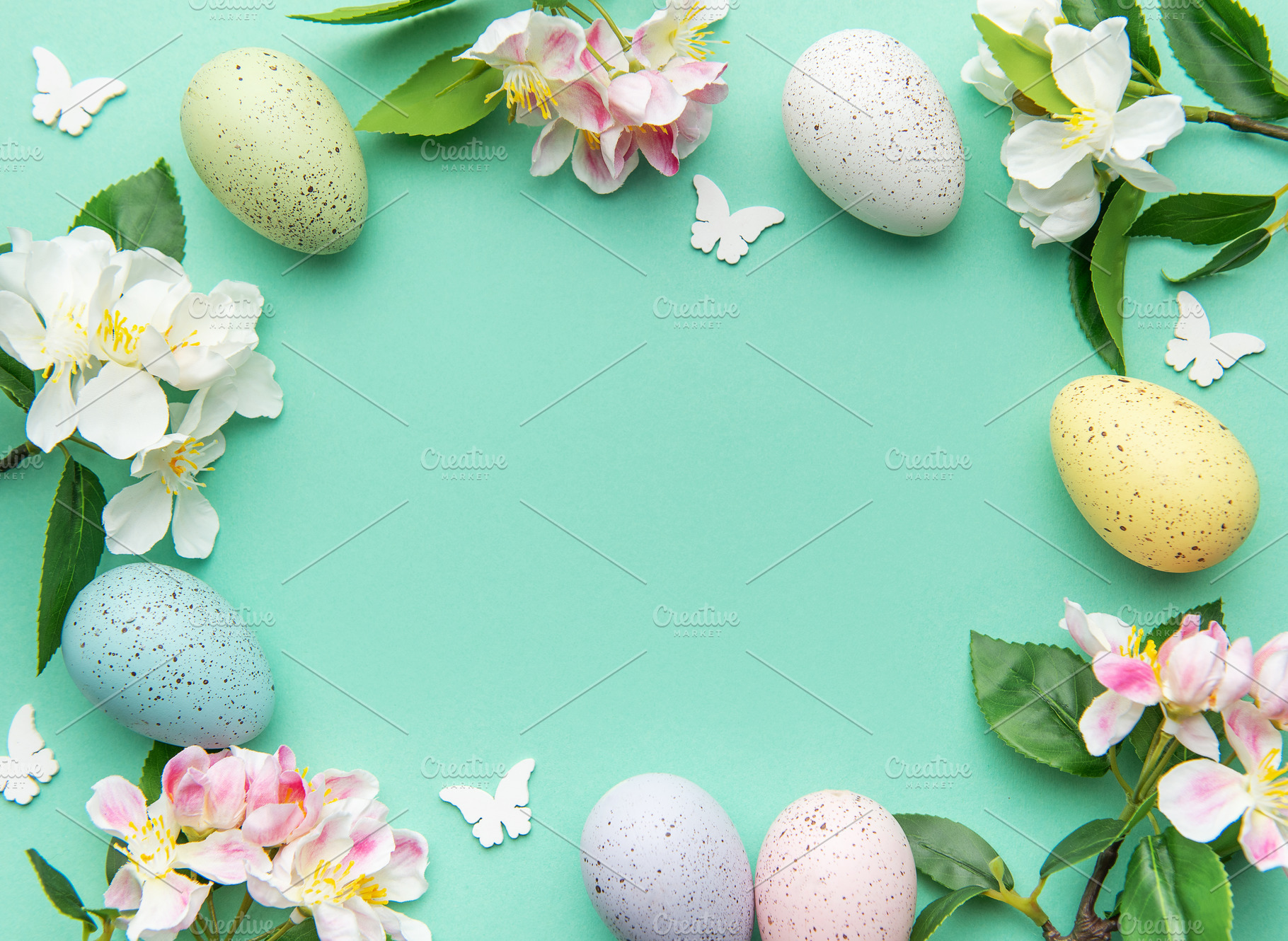 Easter eggs and spring flowers creating a frame on a turquoise b, a Holiday Photo by Olena Rudo