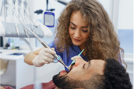 Young woman dentist doing preventive, a Health & Medical Photo by HalfPoint
