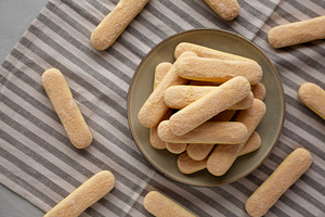 Savoiardi biscuits on a plate, top view., a Food & Drink Photo by LiudmylaChuhunova