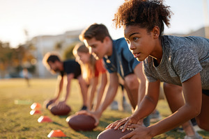 Youth athletes practicing football drills at sunset, a Sports & Recreation Photo by AlyaAnd