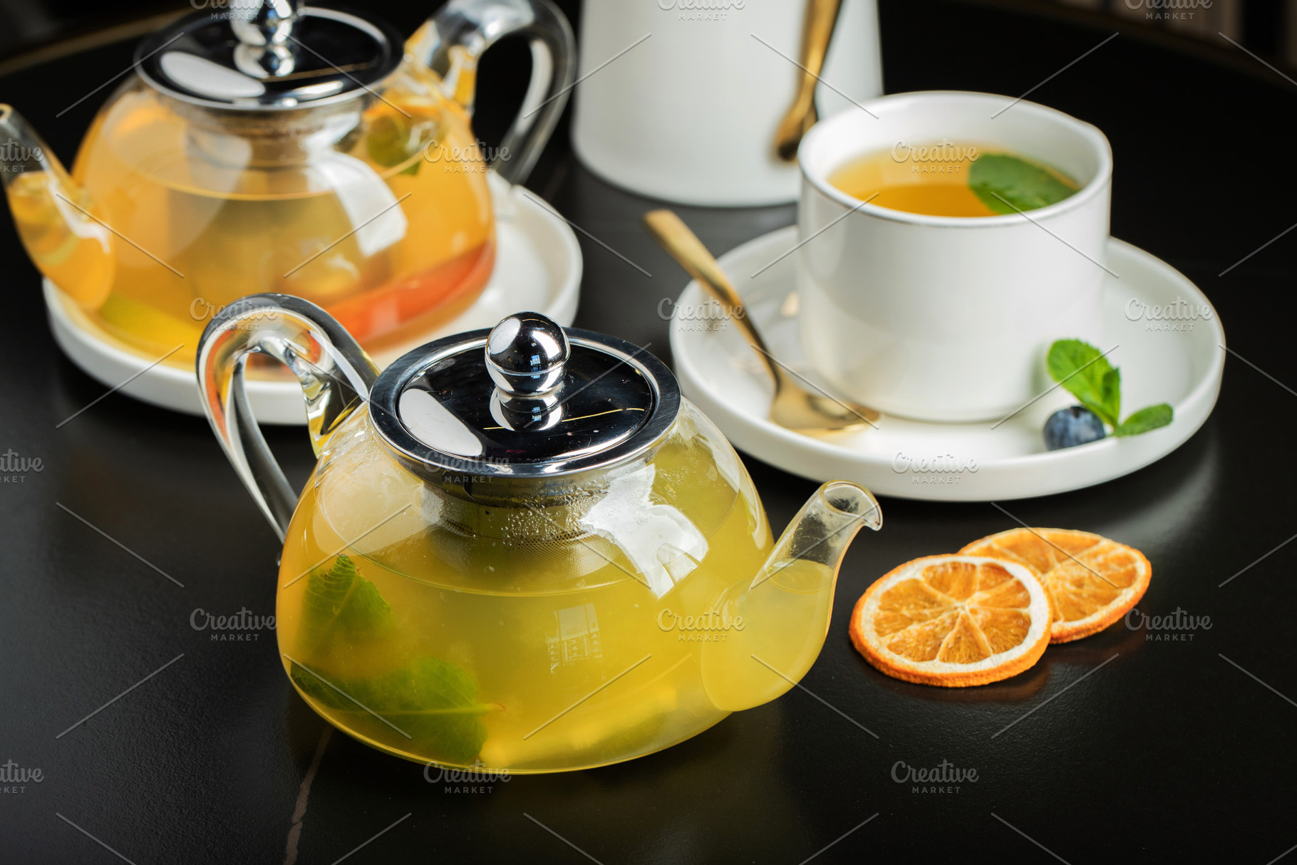 Fruit tea with mango and mint in a glass teapot on the table, a Food & Drink Photo by Budarinphoto