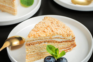 Medovik. Honey cake made from honey cakes with whipped sour cream, decorated wi, a Food & Drink Photo by Budarinphoto