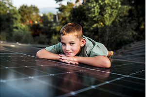 Boy lying on roof with solar panels, a Technology Photo by HalfPoint