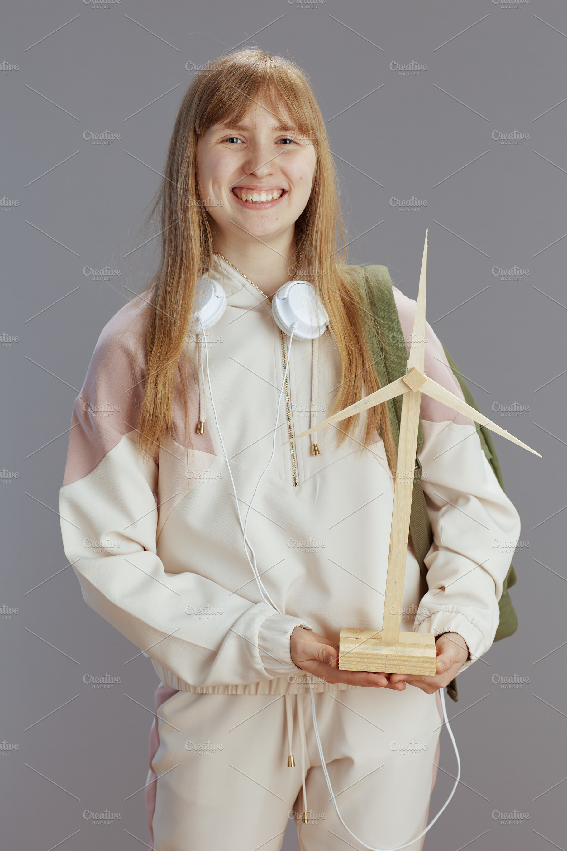 happy modern teen girl in beige tracksuit with headphones, a School & Education Photo by Alliance Images