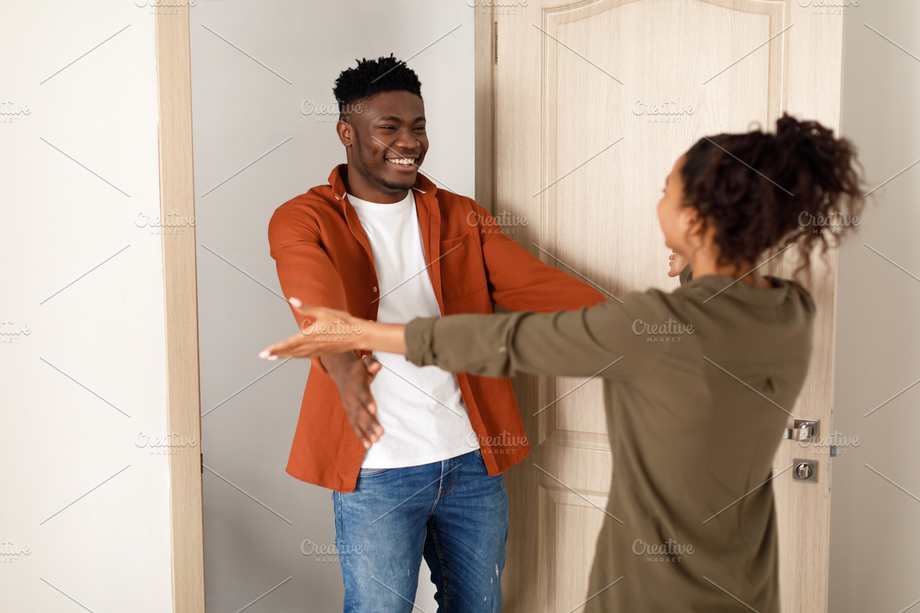 Cheerful Black Couple Stretching Hands For An Embrace At Home, a Photo by Prostock-Studio