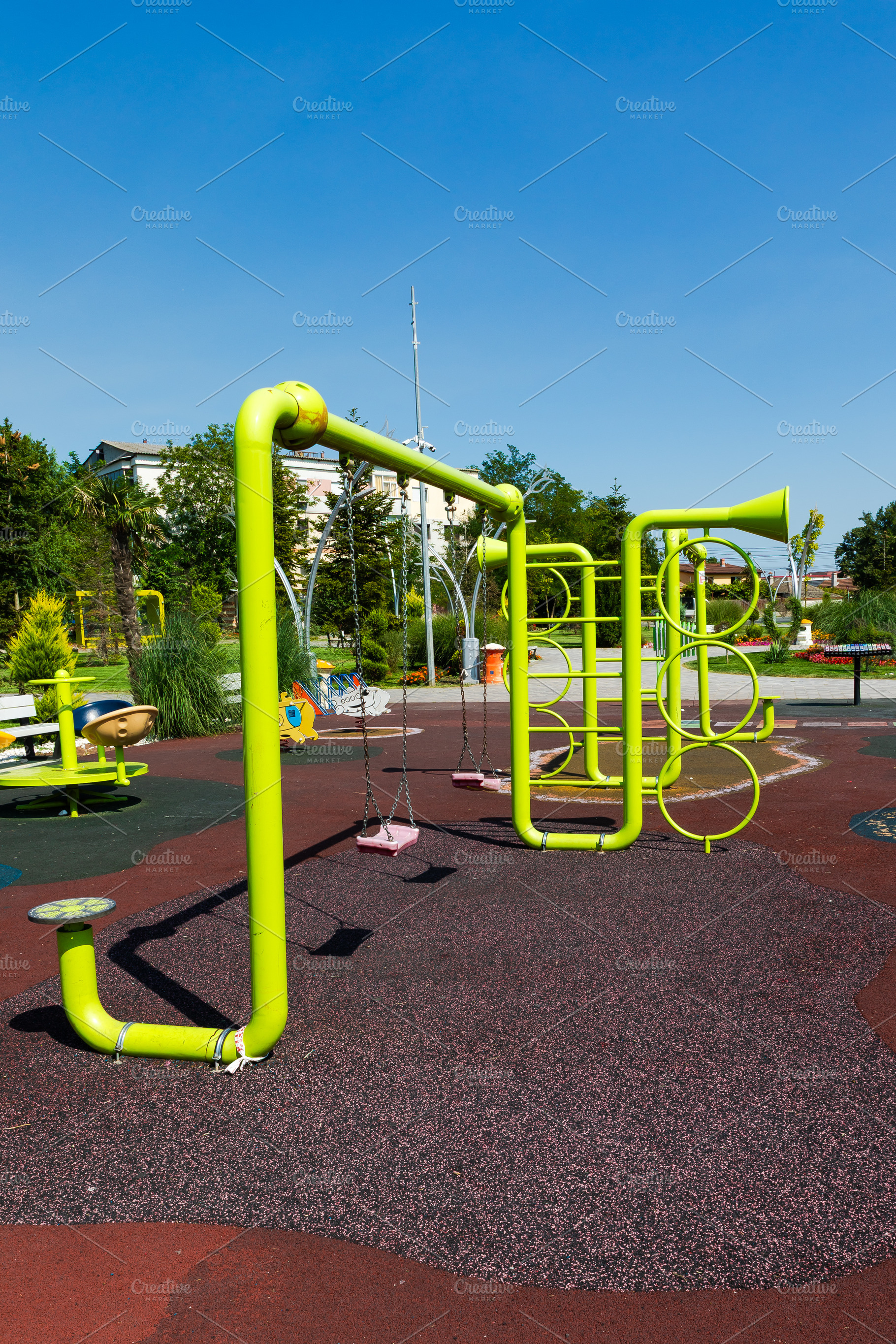 Vibrant green playground structure with swings and climbing elements on a sunny, a Sports & Recreation Photo by Ales Munt