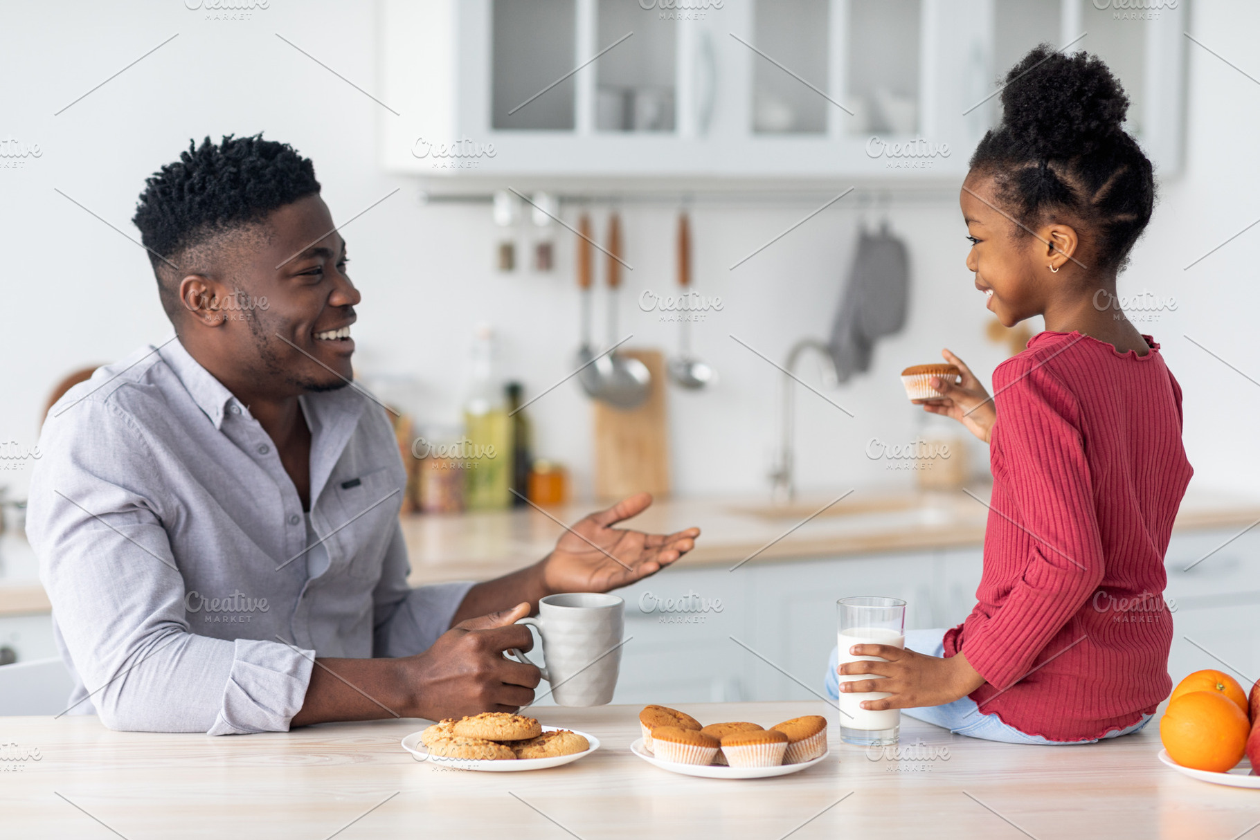 Friendly african american family chatting while having snack, a Photo by Prostock-Studio