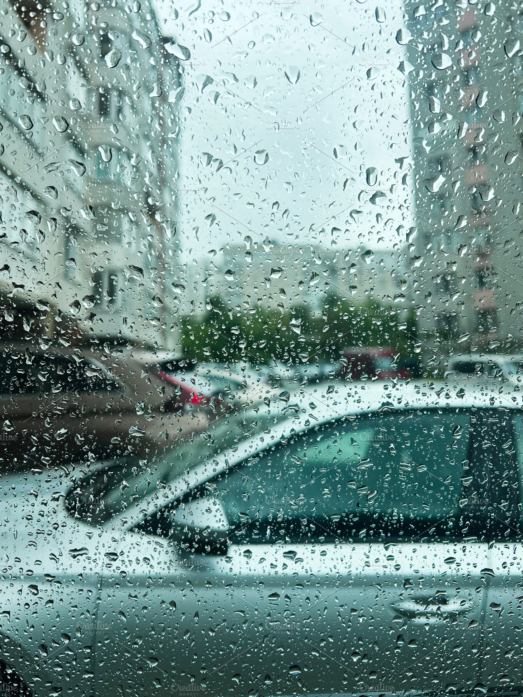 Raindrops on a window with a view of parked cars on a rainy day, a Photo by AS photostudio