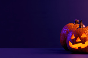 Halloween pumpkins and candy on purple copy space