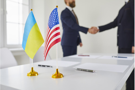 Flags of Ukraine and USA on table, a Business Photo by StudioRomantic