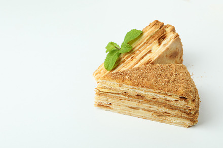 Pieces of honey cake on white background, a Food & Drink Photo by AtlasStudio PRO