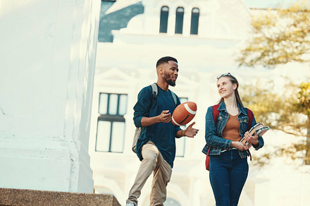 University, students and friends with a woman and man walking down stairs on campus for education. Learning, books and college with a male and female pupil taking a walk to class for studying, a Photo by Peopleimages.com