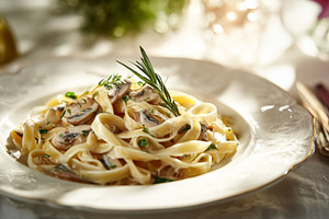 Fettuccine pasta with creamy mushroom sauce, fresh rosemary, and, a Photo by Studio ANNA