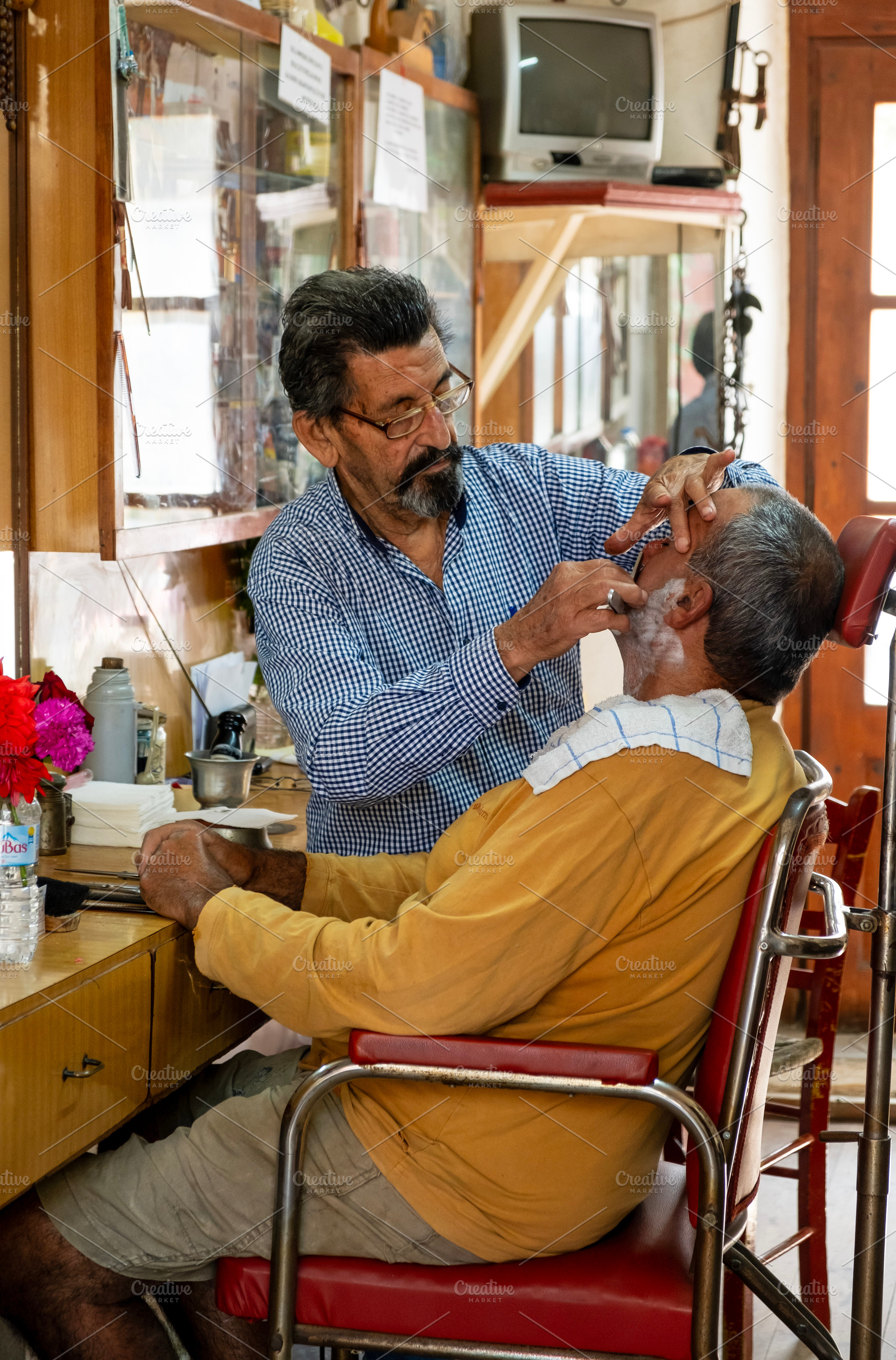 Elderly barber man in barber shop, a Person Photo by BOOCYS
