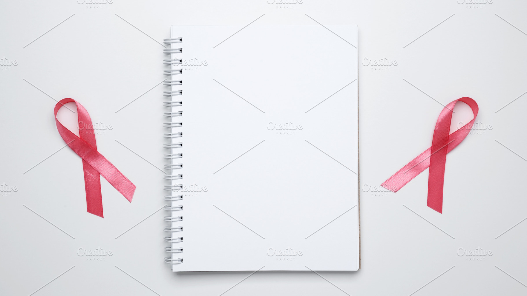 Pink ribbon lying on open notebook symbolizing support and reminder for breast, a Photo by matucha
