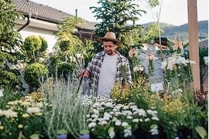 Garden center owner working among, a Nature Photo by HalfPoint