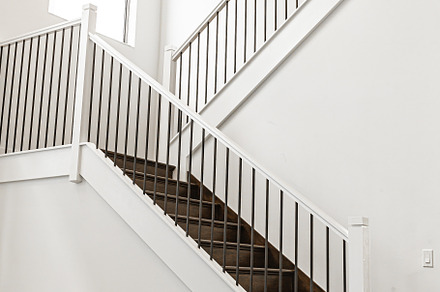 Modern white wooden staircase in new house interior with big windows