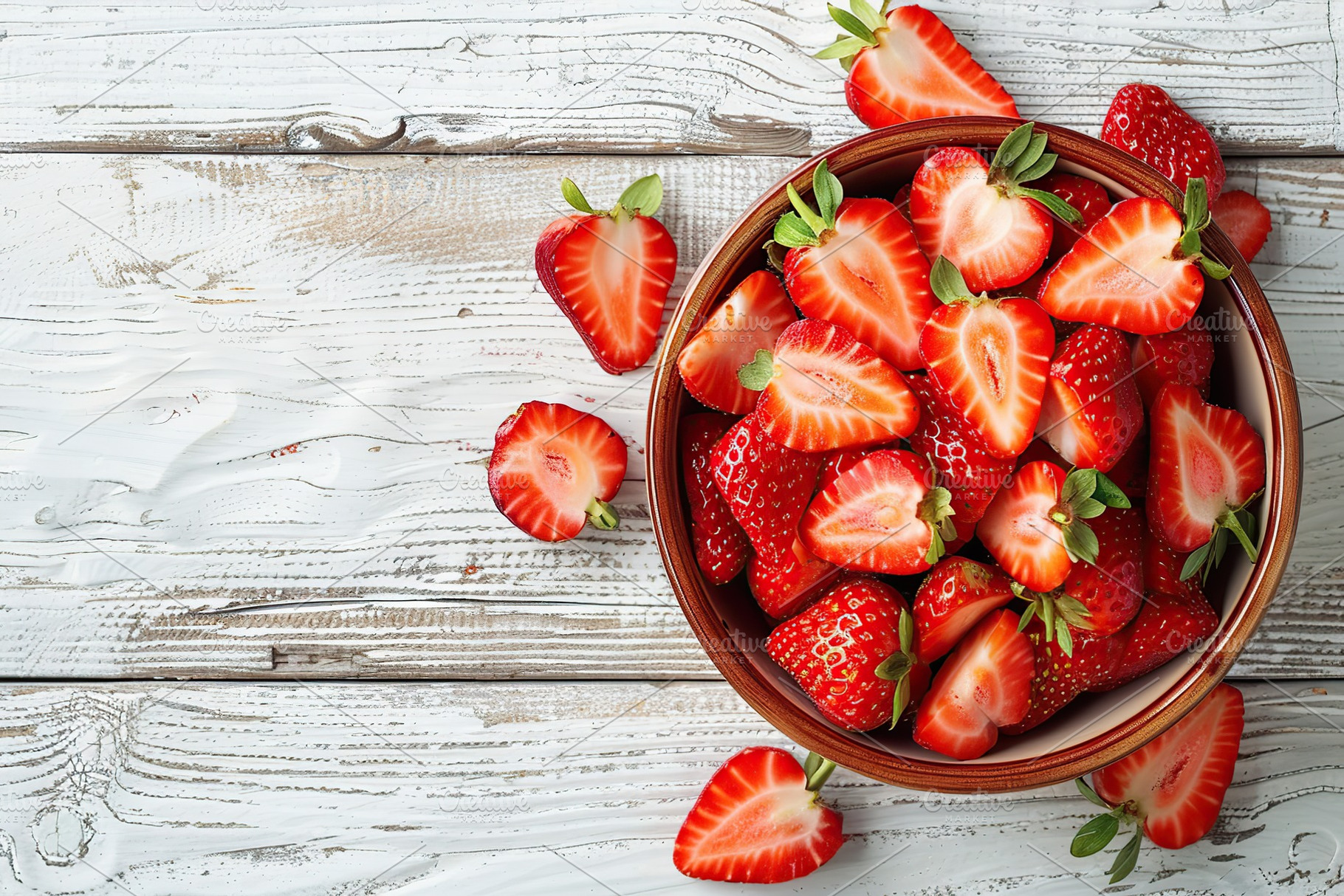 Pieces of strawberries in bowl on wooden table, a Food & Drink Photo by AlyaAnd