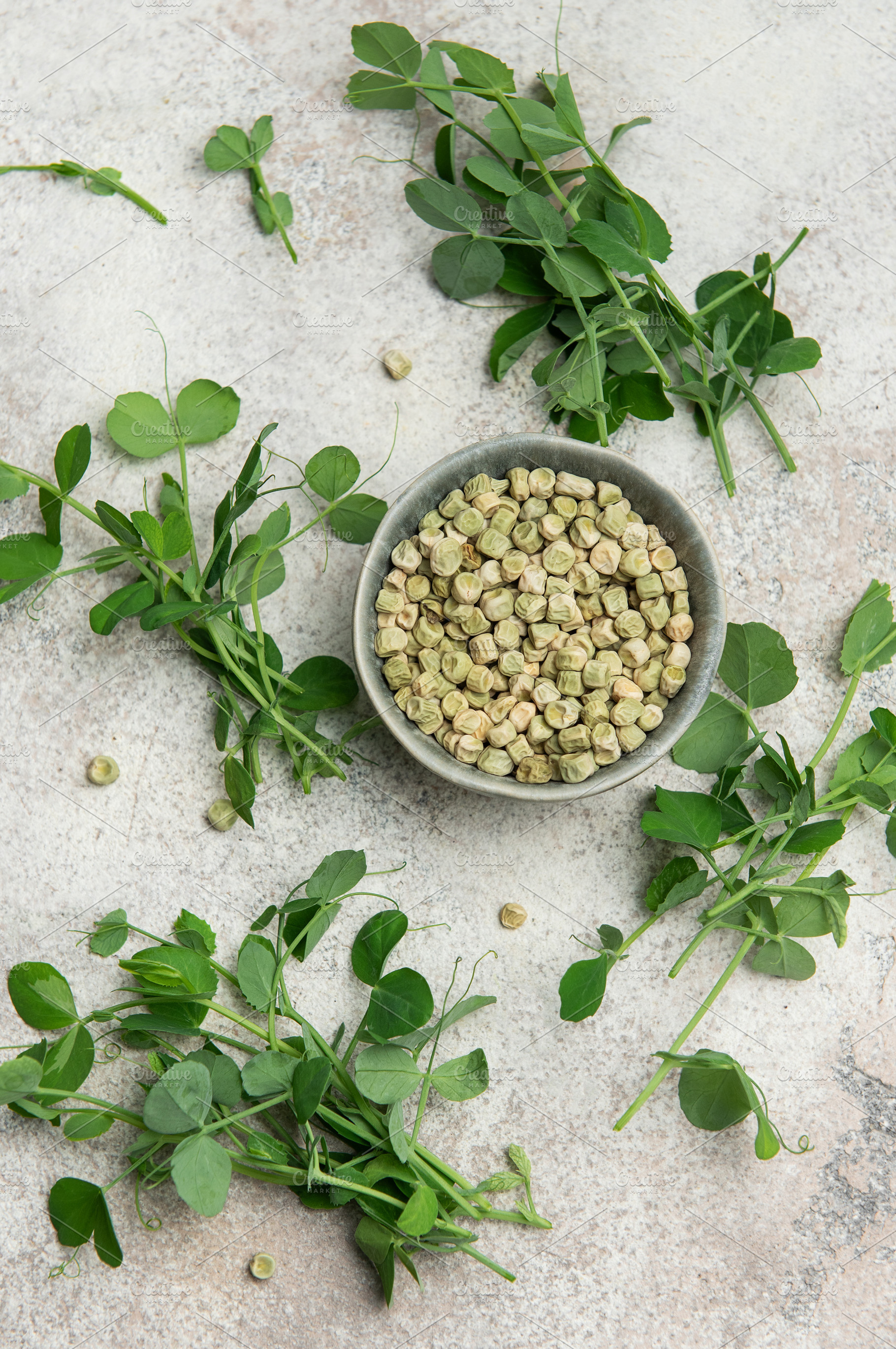 Dried green peas in bowl with fresh pea shoots on marble backgro, a Food & Drink Photo by Olena Rudo