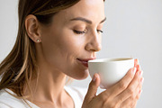 Woman enjoying morning tea with gentle satisfied expression, a Person Photo by GoodGoods (Thumbnail 1 of 2)