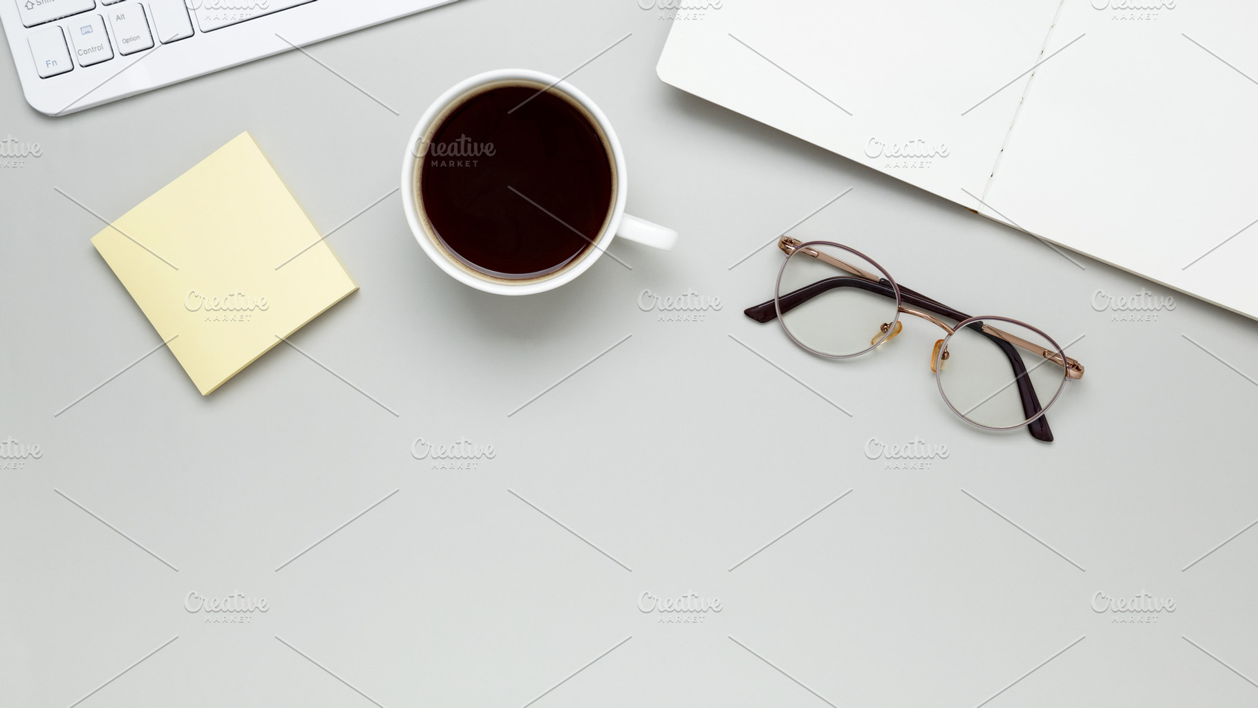 Cozy workspace with coffee, keyboard, glasses, and notebook setting a focused m, a Photo by matucha