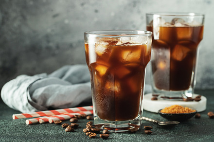 Ice coffee in a tall glass with cream poured over, ice cubes and beans on a dar, a Food & Drink Photo by Budarinphoto