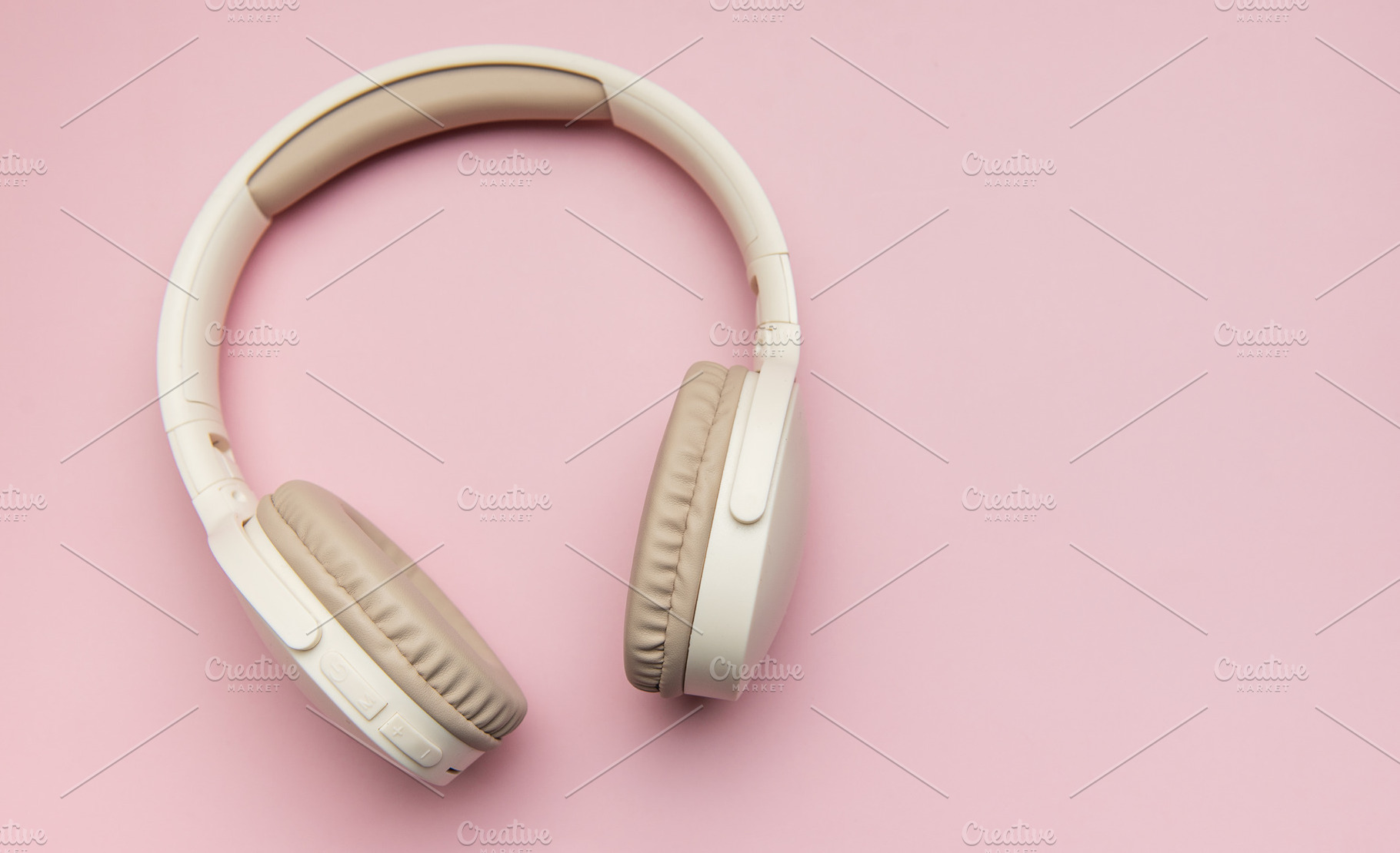 Modern wireless headphones lying on pink background, a Technology Photo by Olena Rudo