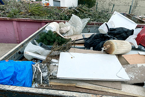a container filled with bulky waste at a recycling site, a Photo by Nito