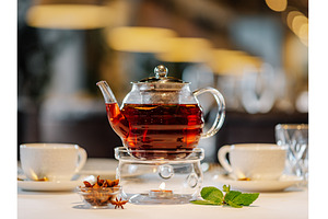 Glass teapot with warmer on table in, a Food & Drink Photo by Fascinadora