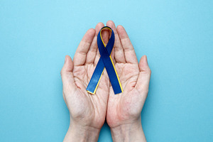 Symbolizing World Down Syndrome Day. A person holds a yellow and blue awareness, a Photo by matucha