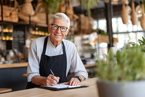 Smiling senior cafe owner in apron, a Food & Drink Photo by MistyDay