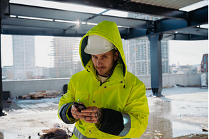 Construction worker text messaging, an Industrial Photo by HalfPoint