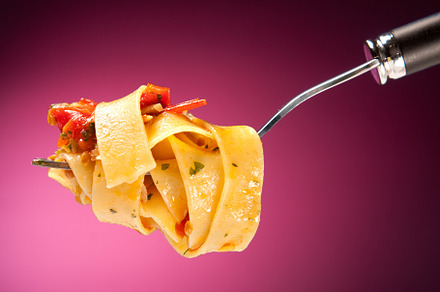 Tagliatelle with clams on a red background