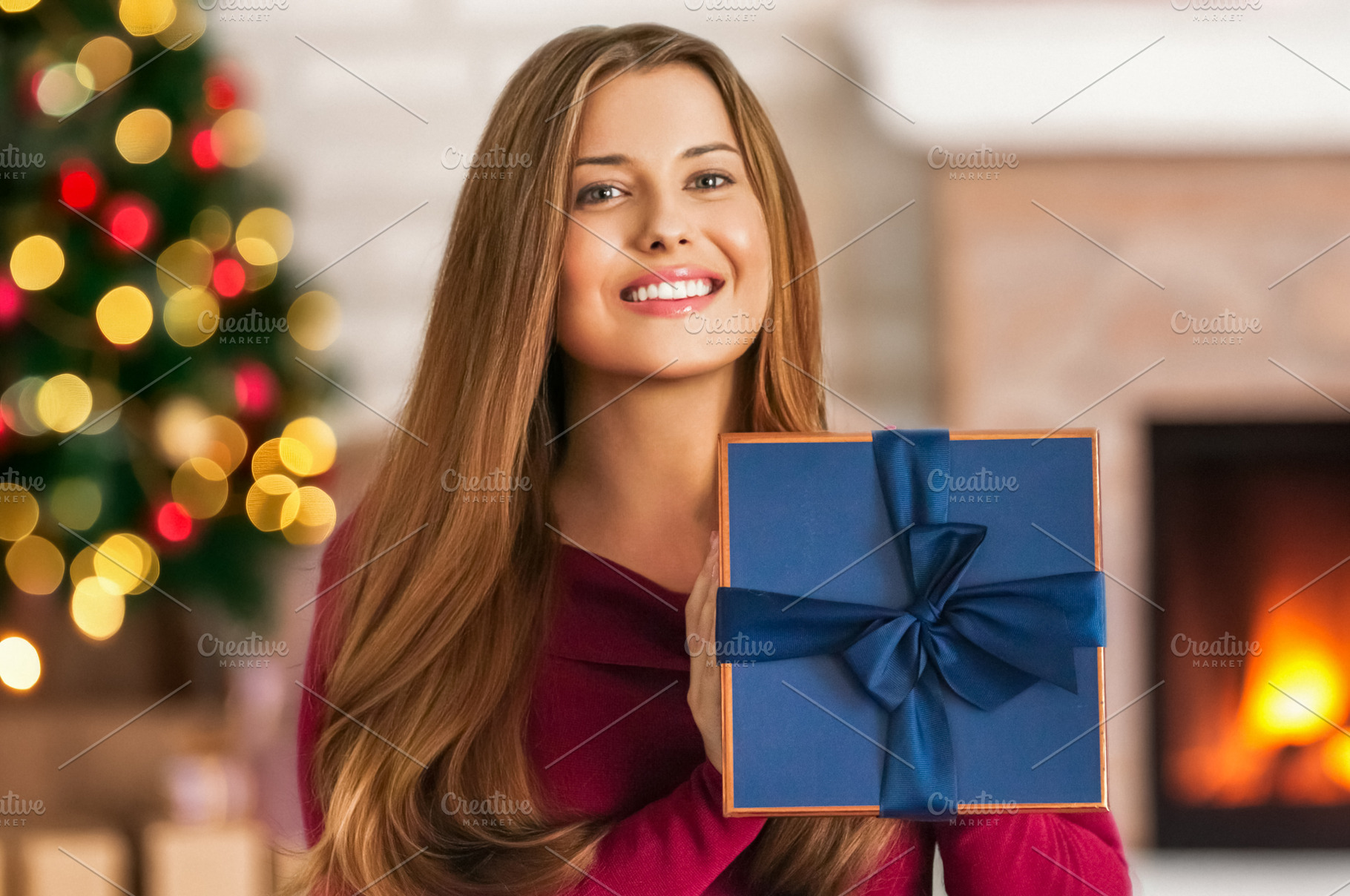 Woman holding a blue gift box, celebrating Christmas holidays wi, a Person Photo by Studio ANNA