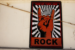 Rock music hand gesture art sign on a textured urban wall, a Photo by AS photostudio