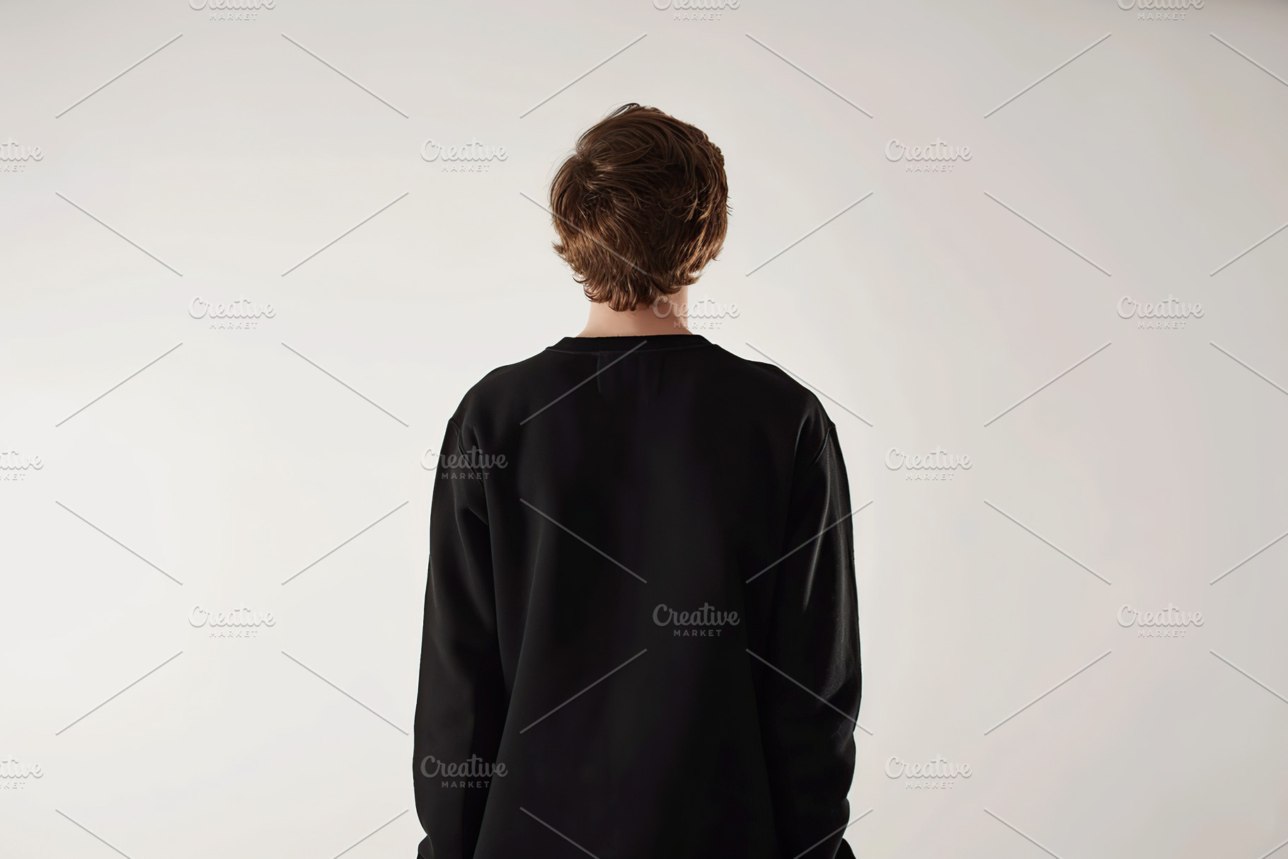 Young man in black sweatshirt on grey background, back view, a Beauty & Fashion Photo by AlyaAnd