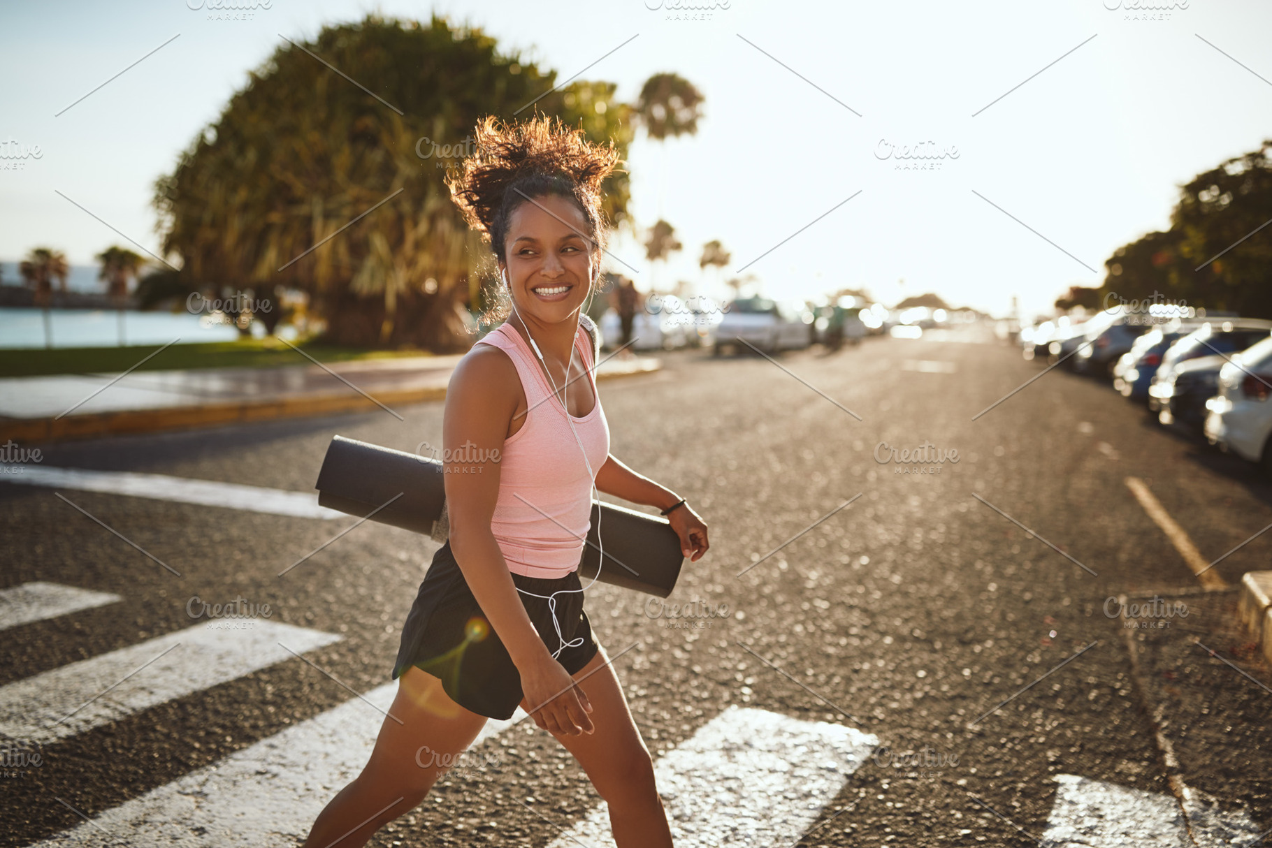 Sporty woman smiling enthusiastically while walking to yoga clas, a Sports & Recreation Photo by Stefan & Janni
