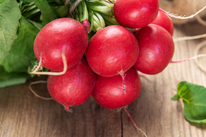 Fresh organic radishes with green leaves on wood, a Food & Drink Photo by Olena Rudo