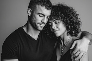Couple sharing an intimate moment with closed eyes in a warm embrace, a Photo by AlyaAnd
