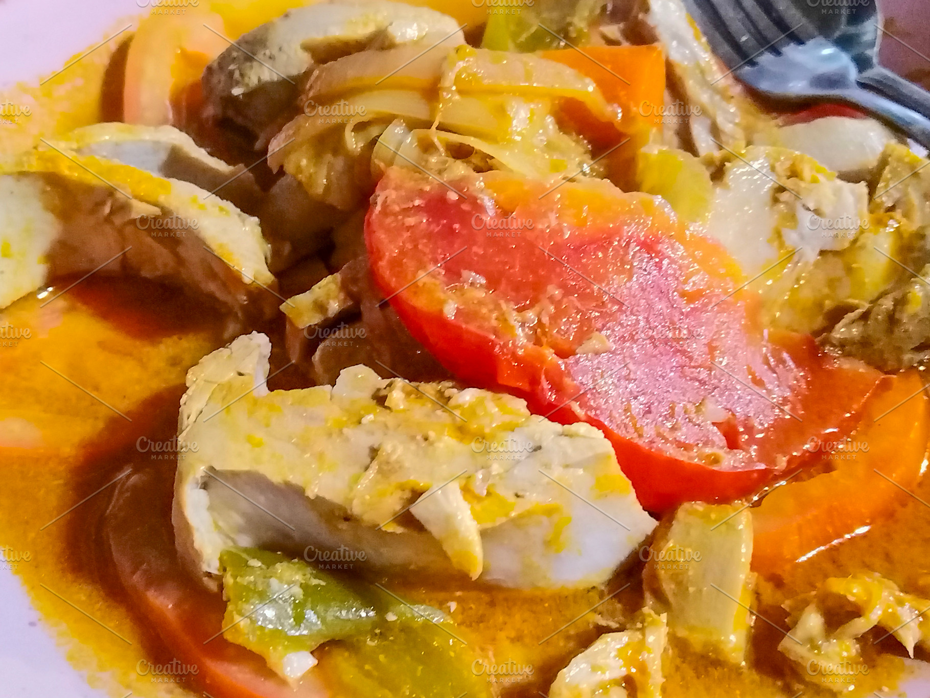 Fish stew with tomato and vegetables on pink plate, a Food & Drink Photo by DanFLCreativo
