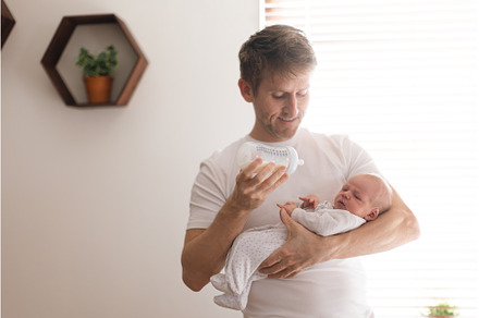 Father holding and feeding his, a Person Photo by HalfPoint