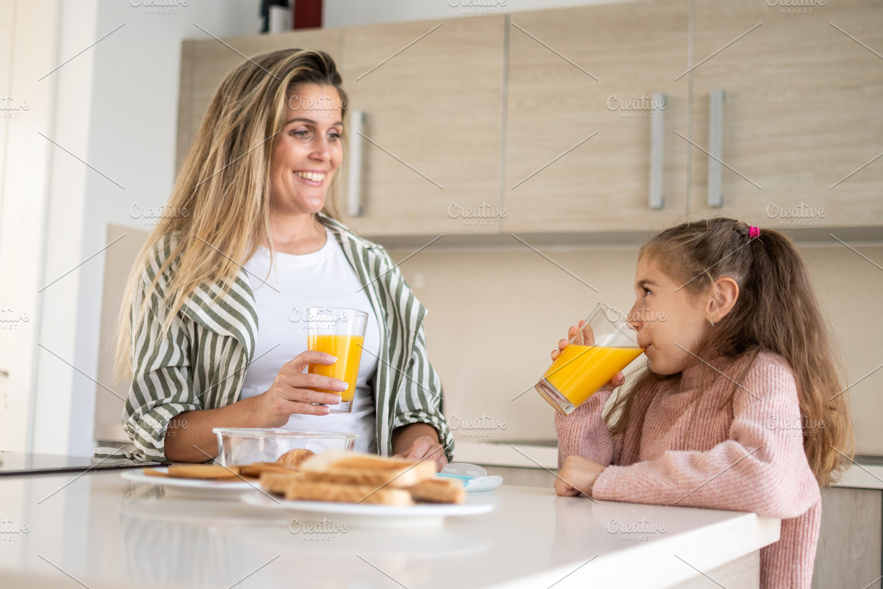 Mother and daughter enjoying healthy breakfast together in modern kitchen, a Person Photo by etorres69