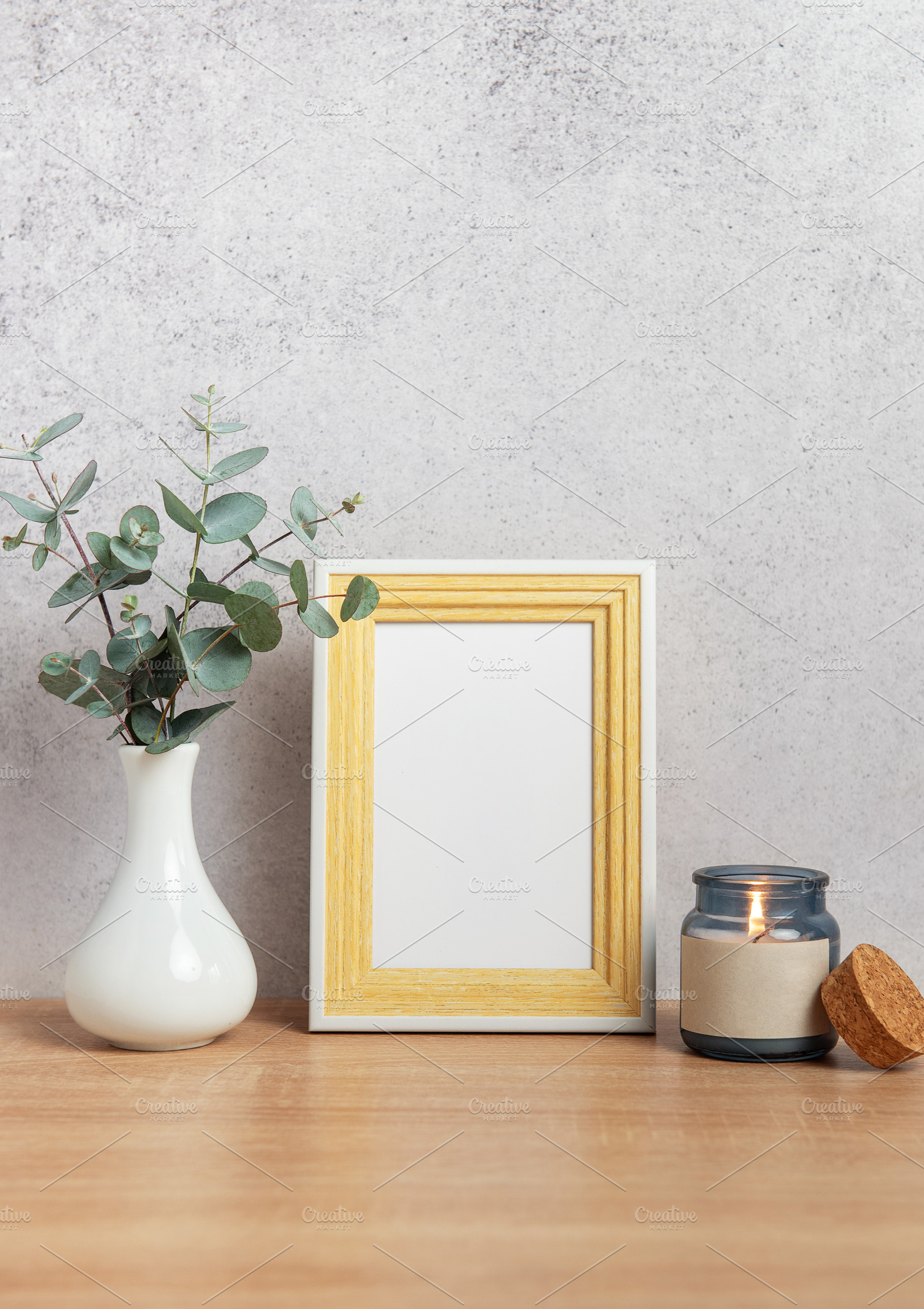 Eucalyptus branches, lit candle and empty photo frame creating c, a Background Photo by Olena Rudo