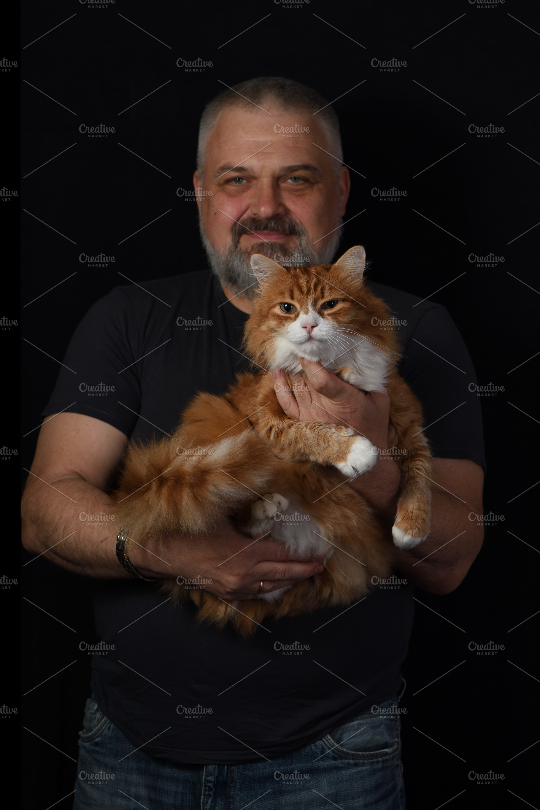 man holding a ginger cat against, an Animal Photo by Apolonia